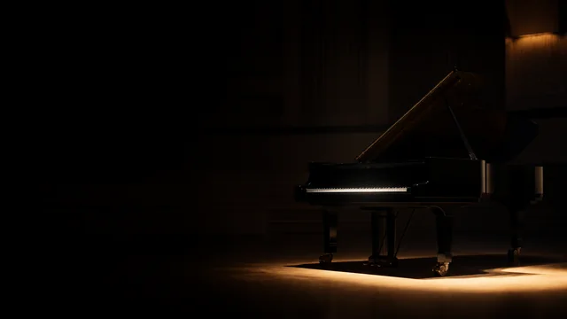 Concert grand piano in a beam of warm light